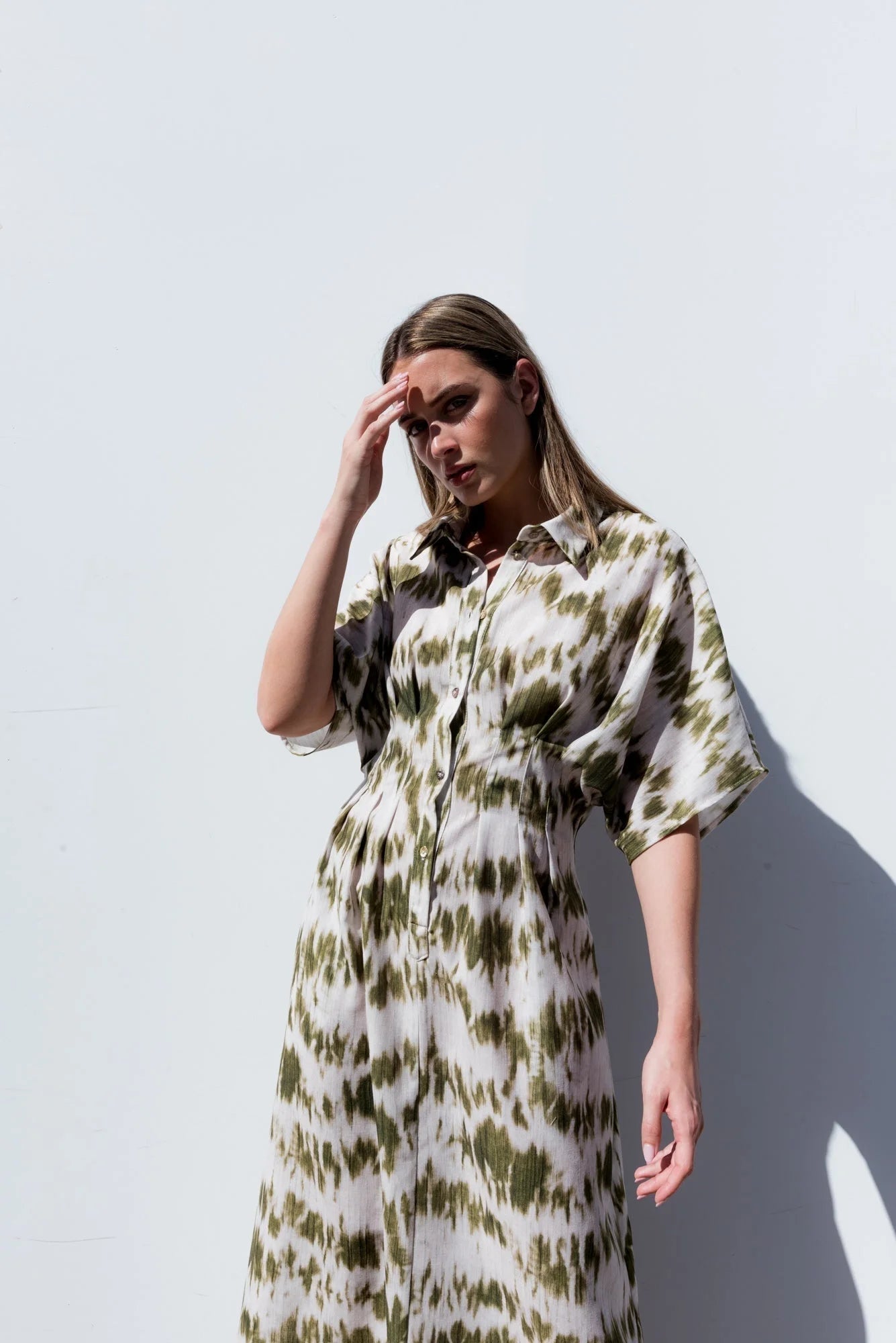Femme portant une robe chemise imprimée tie-dye vert olive courte et élégante