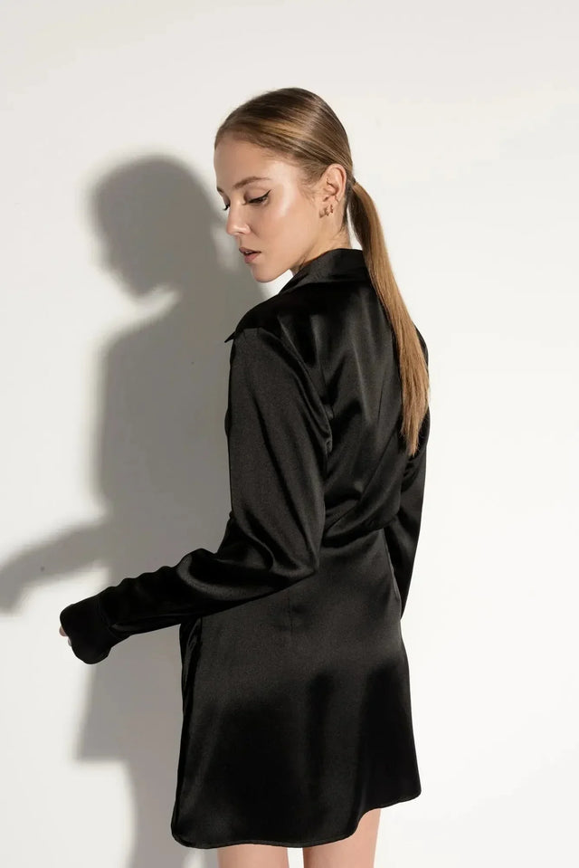 Robe chemise satin noir courte – Élégante et chic avec effet portefeuille croisé, vue arrière sur un mannequin, mettant en valeur le design fluide et féminin.