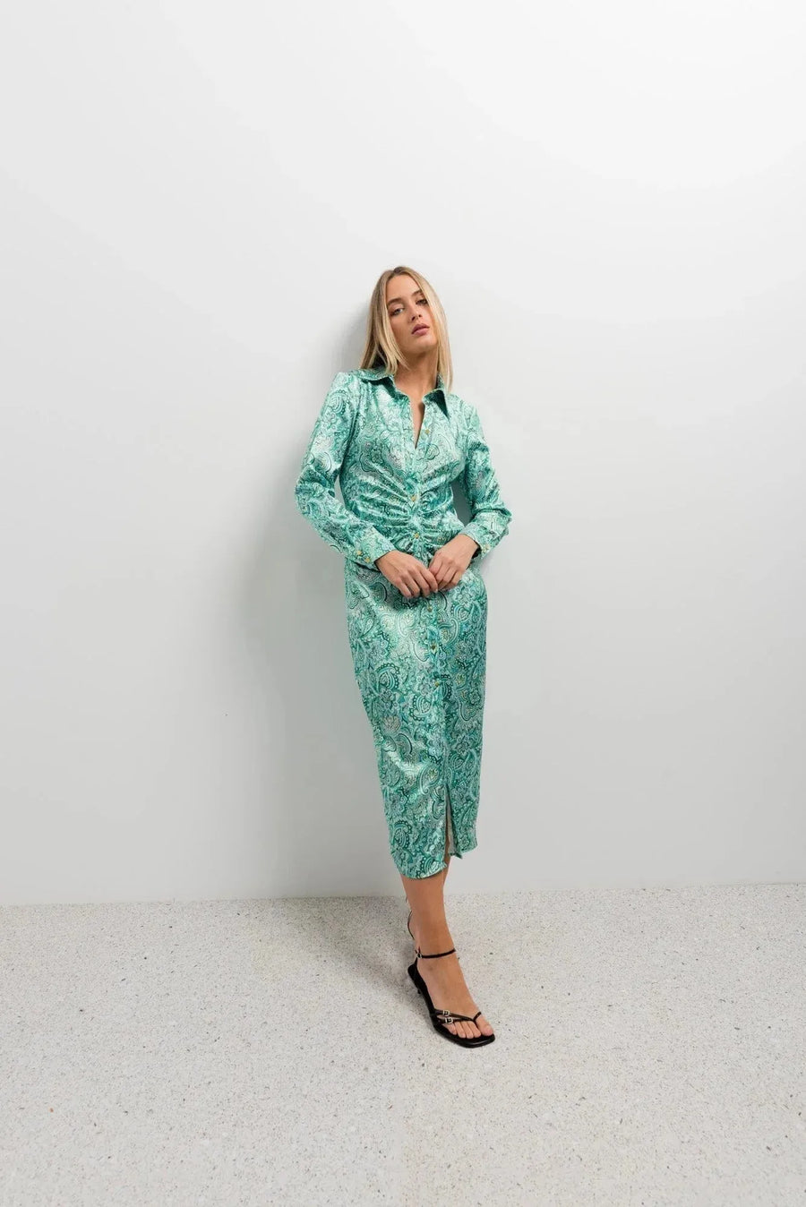 Femme posant avec la robe chemise verte midi satinée à imprimé cachemire, prêt à être portée pour une occasion spéciale.