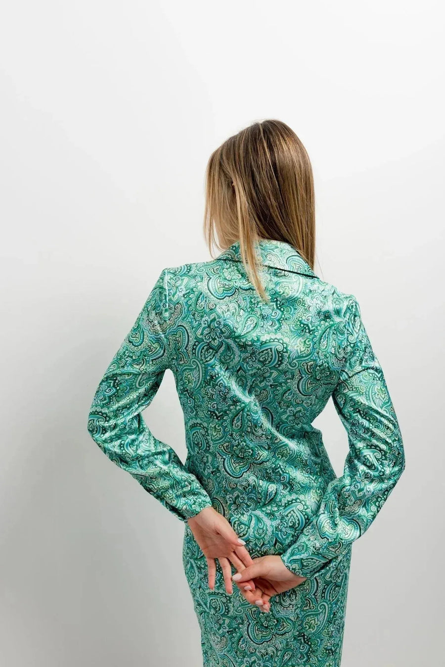 Vue arrière d'une femme en robe chemise verte qui met en avant le design chic et les détails raffinés de cette pièce.
