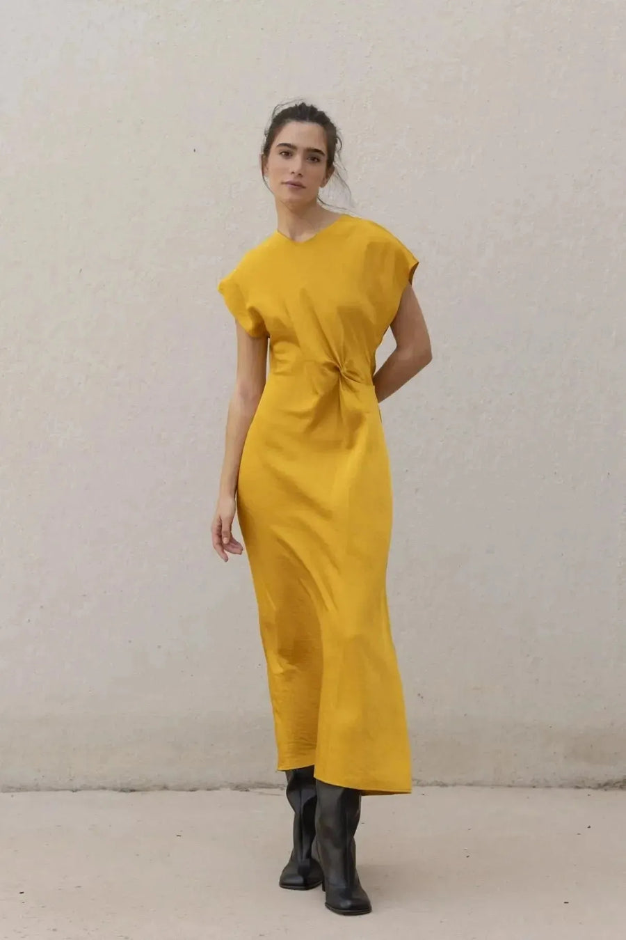 Robe De Soirée Jaune Satinée Élégante Avec Nœud À La Taille - Chic Et Fluide, modèle tourné légèrement en robe de soirée jaune, mettant en valeur le nœud à la taille.