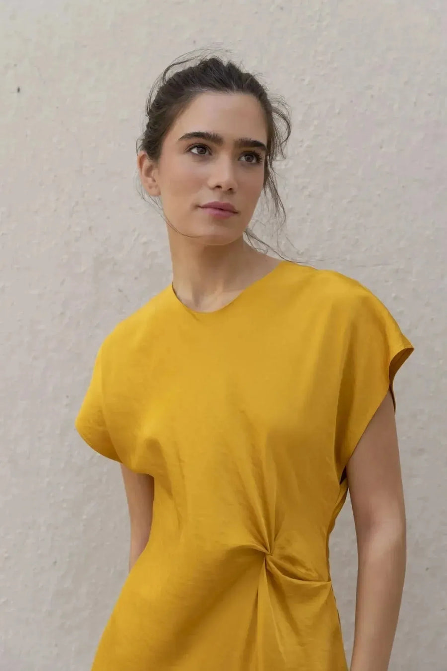 Robe De Soirée Jaune Satinée Élégante Avec Nœud À La Taille - Chic Et Fluide, gros plan sur un modèle féminin souriant en robe de soirée jaune satinée.