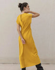 Robe De Soirée Jaune Satinée Élégante Avec Nœud À La Taille - Chic Et Fluide, vue arrière d'une modèle en robe de soirée jaune avec un design ouvert.