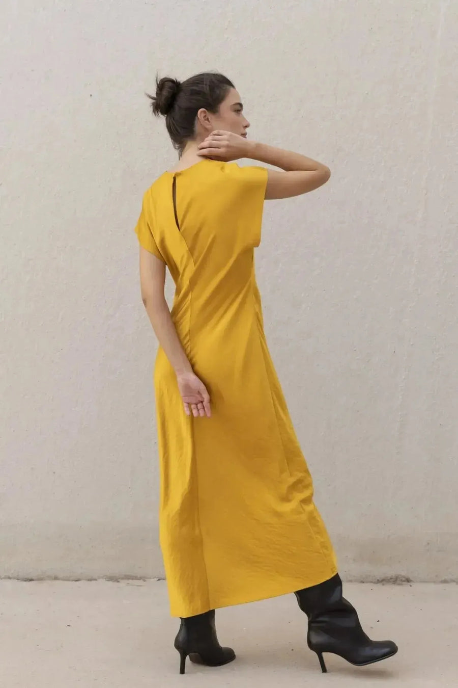 Robe De Soirée Jaune Satinée Élégante Avec Nœud À La Taille - Chic Et Fluide, une autre vue arrière d'une modèle en robe de soirée jaune satinée.