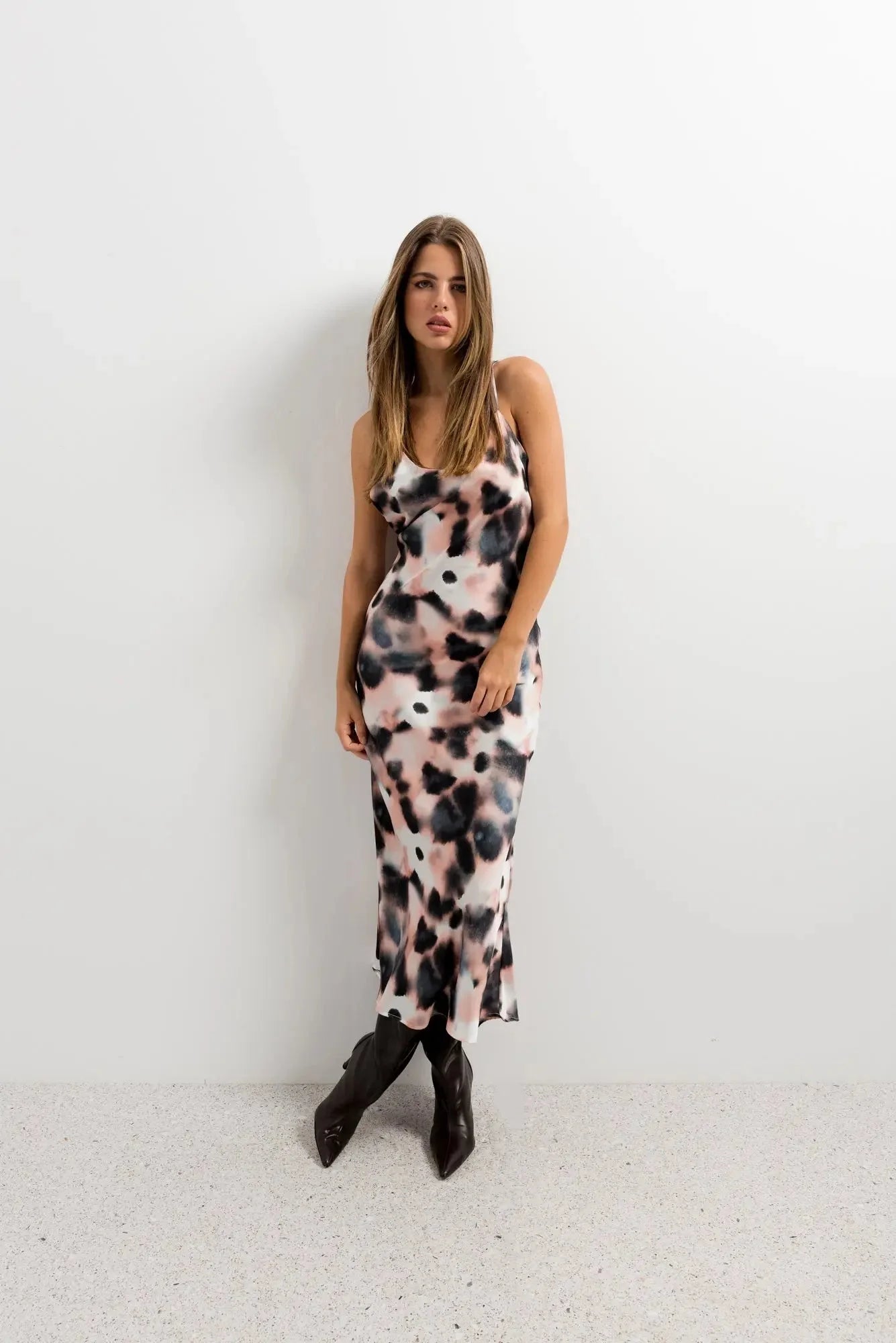 Modèle debout dans une robe longue à imprimé tie-dye, silhouette élégante avec un fond neutre, parfaite pour une journée relaxante ou une sortie estivale, robe tie and dye très à la mode.