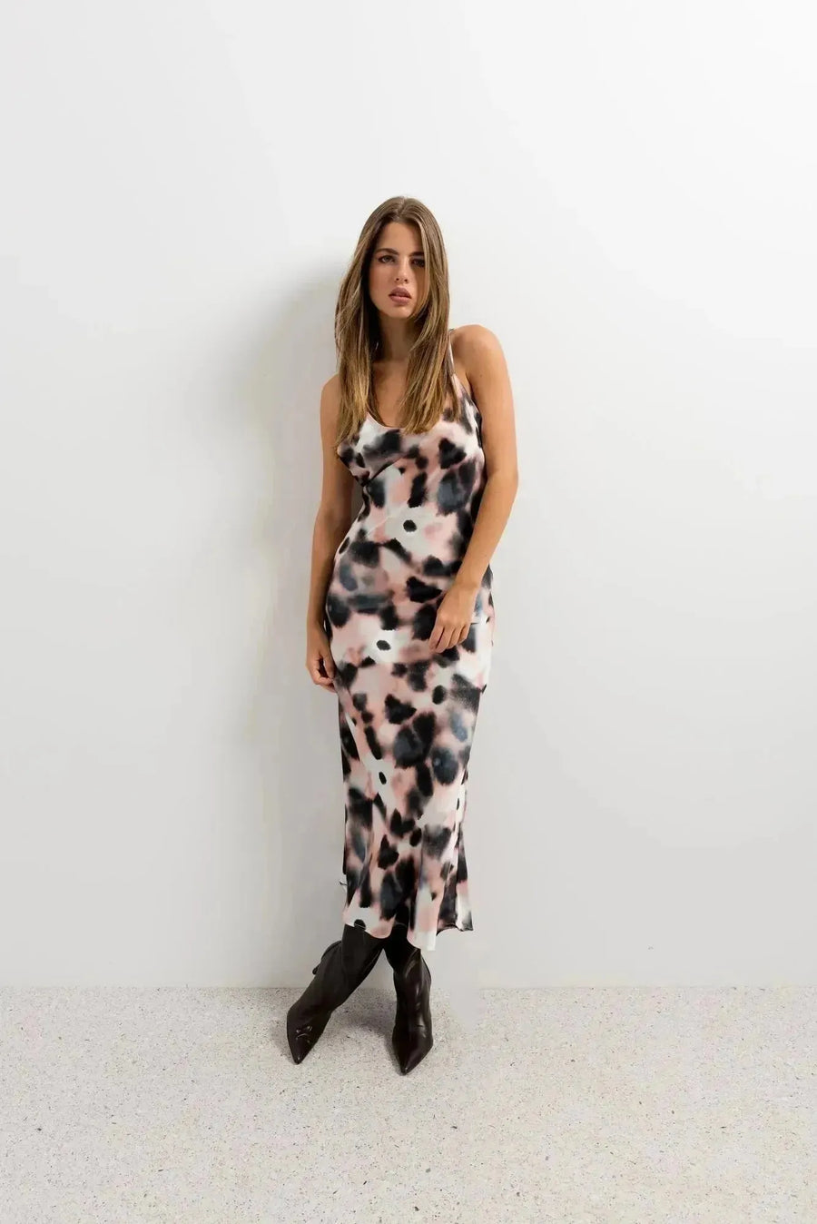 Modèle debout dans une robe longue à imprimé tie-dye, silhouette élégante avec un fond neutre, parfaite pour une journée relaxante ou une sortie estivale, robe tie and dye très à la mode.