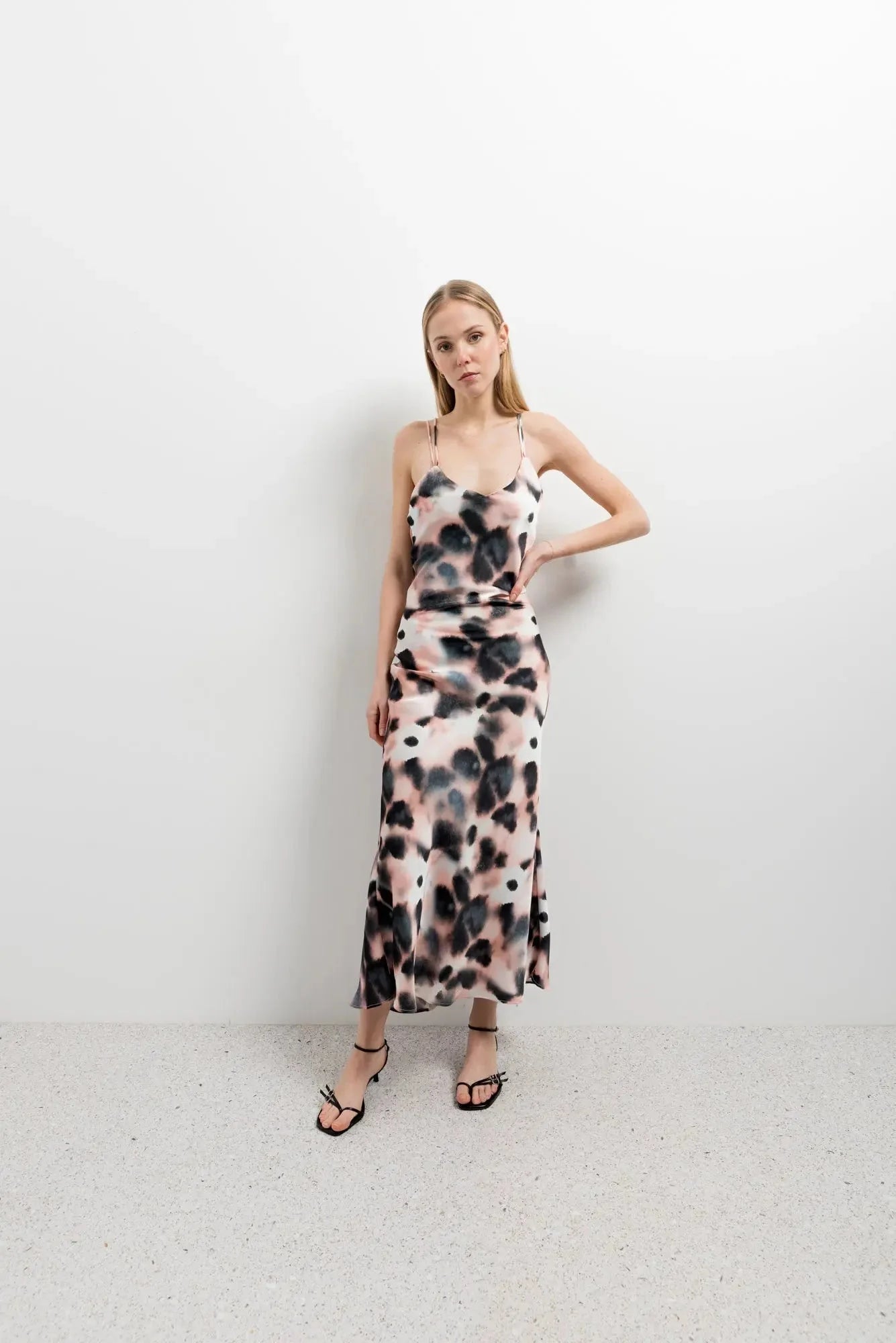 Femme posant dans une robe longue à imprimé tie-dye, associée à des accessoires modernes, mettant en évidence son allure chic et décontractée, une robe tie and dye pour toutes les occasions.