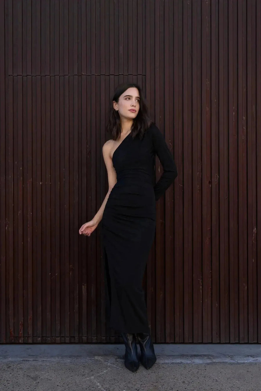 Modèle en robe asymétrique une manche noire, capturant le style chic et la sophistication adaptée aux réceptions et aux soirées.