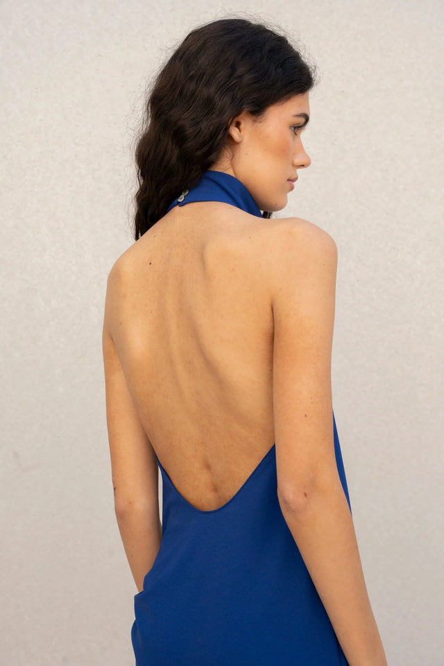 Détail du dos de la robe longue dos nu Sapiato sur un modèle, mettant en avant l'élégance minimaliste du vêtement.