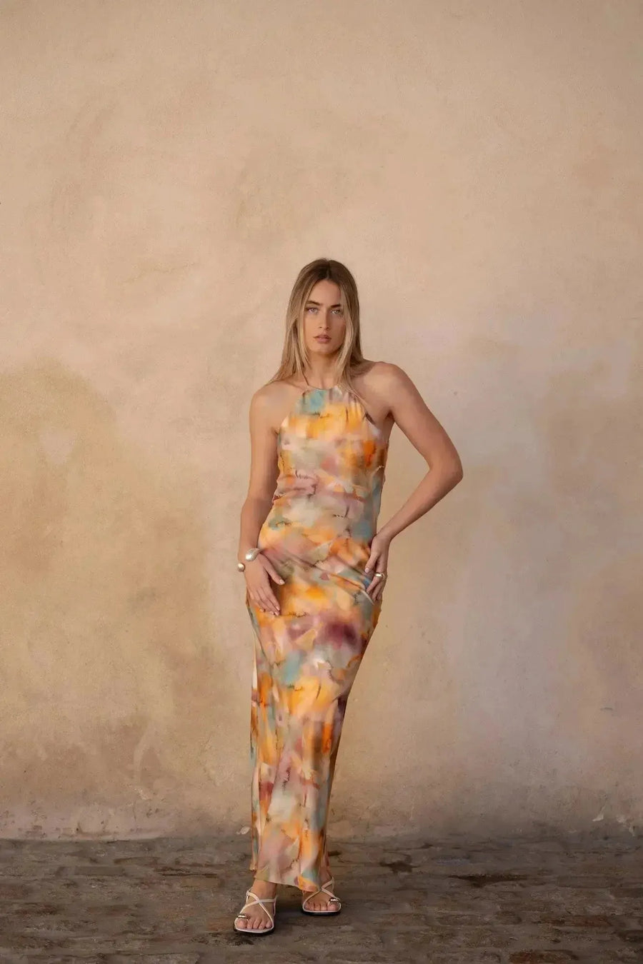 Modèle mettant en avant la robe satin longue dos nu imprimée aquarelle multicolore – Élégance fluide et chic, capturant une allure sophistiquée.