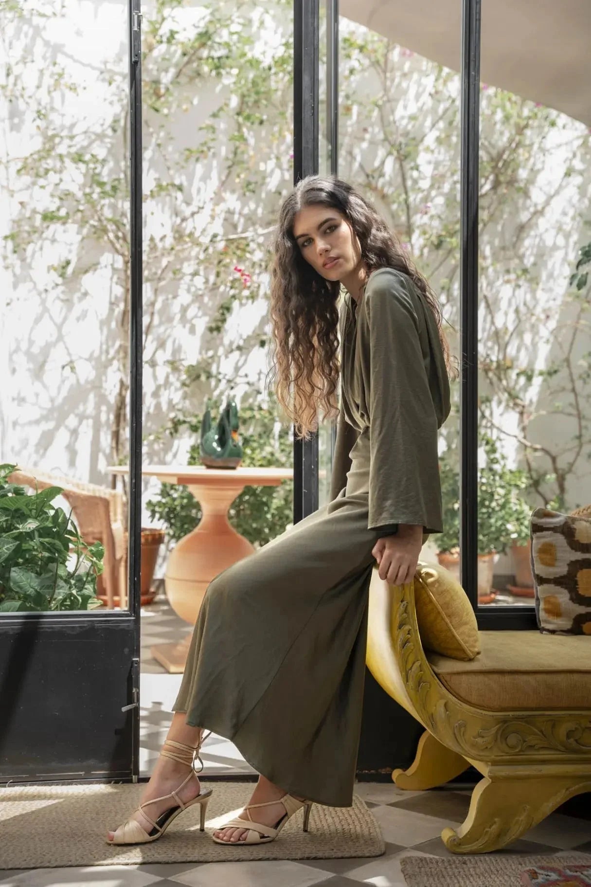 Femme en robe longue en satin olive pour sortie décontractée et élégante
