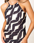 Robe Longue Col Halter Imprimée Graphique Noir et Beige – Élégance Estivale. Détail de la robe longue col halter, soulignant le motif graphique en noir et beige.