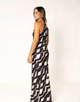 Robe Longue Col Halter Imprimée Graphique Noir et Beige – Élégance Estivale. Femme montrant le dos de la robe longue col halter, mettant en valeur son élégance sophistiquée.