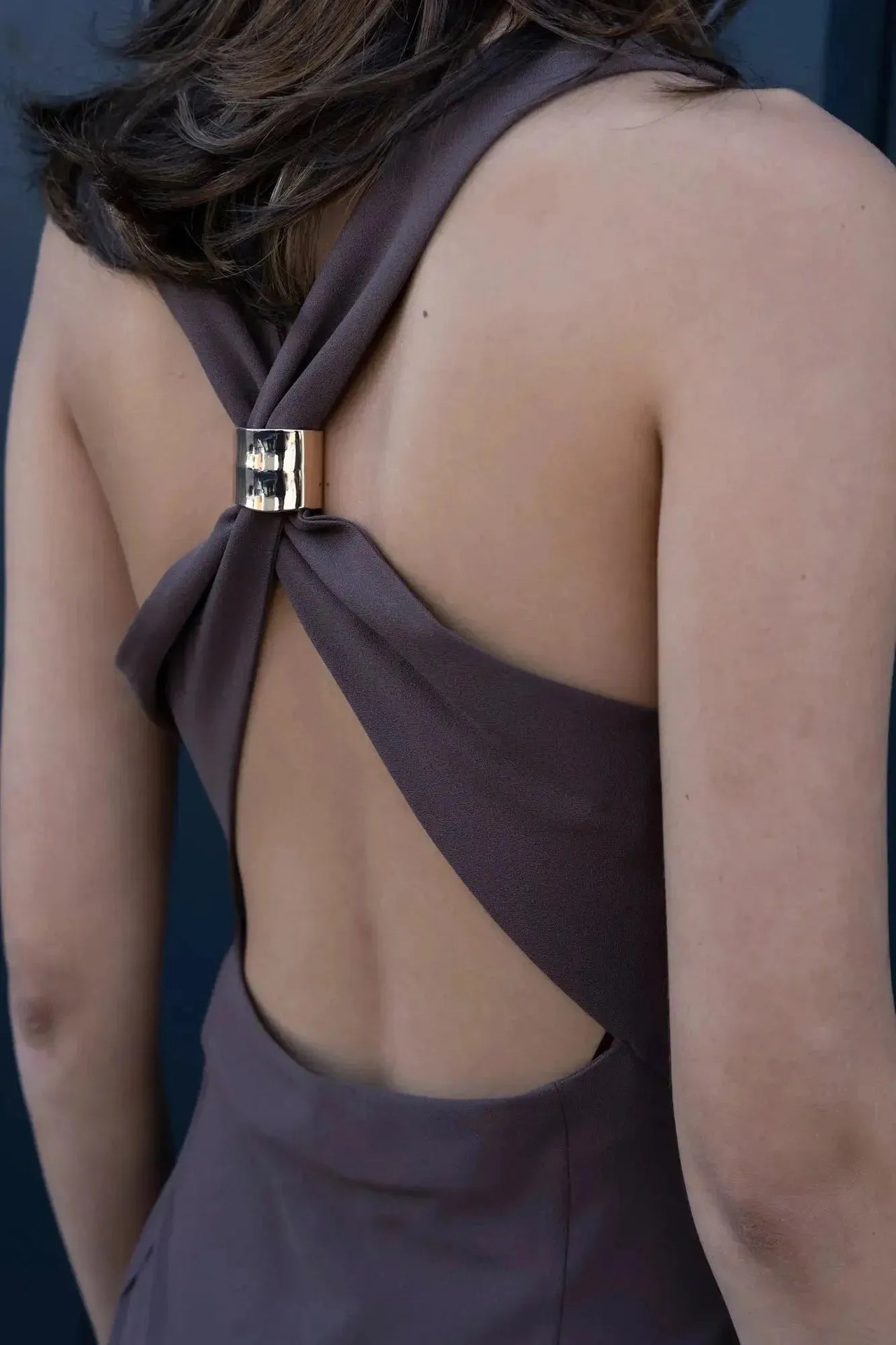 Détail du dos d'un modèle en robe longue mariage civil détail doré, montrant le design du dos nu et la finition raffinée de la robe longue dos nu.