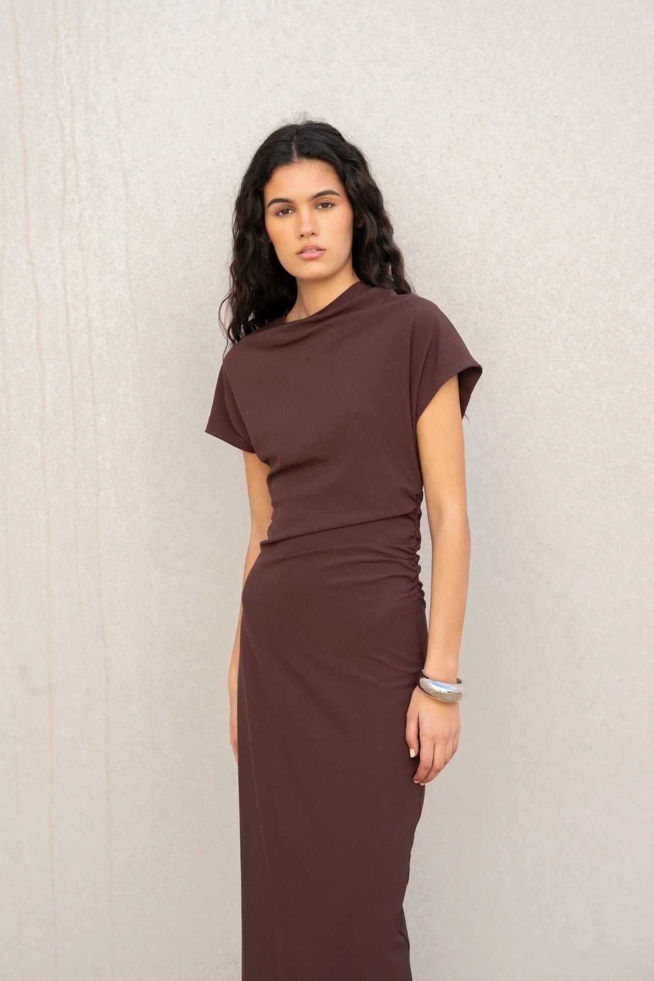 Femme portant une robe midi drapée élégante avec détails drapés et taille ruchée