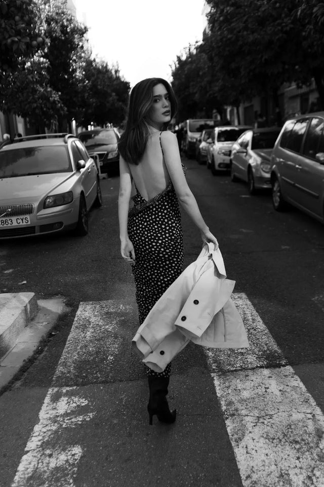 Modèle féminin marchant dans la rue, avec une robe longue marron à pois et volants, capturant l'essence d'un look estival avec la robe à pois marron.