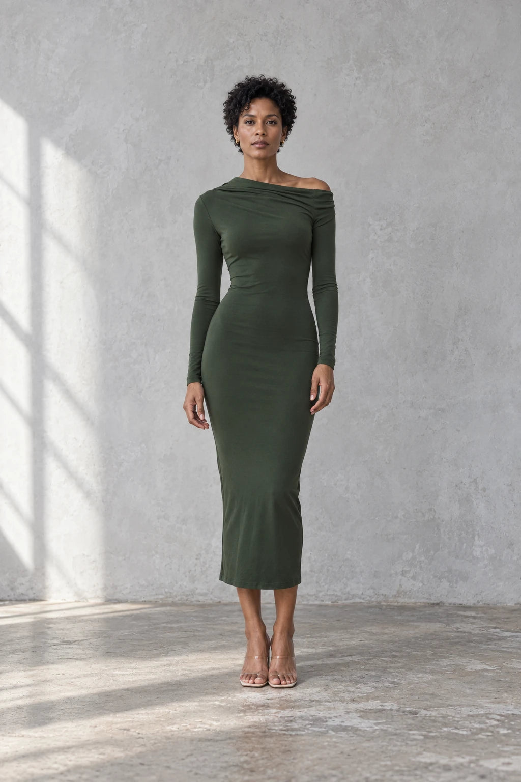 Modèle en robe moulante kaki femme à épaule dénudée, regardant l'objectif, illustrant l'élégance et le style contemporain de la robe moulante kaki.