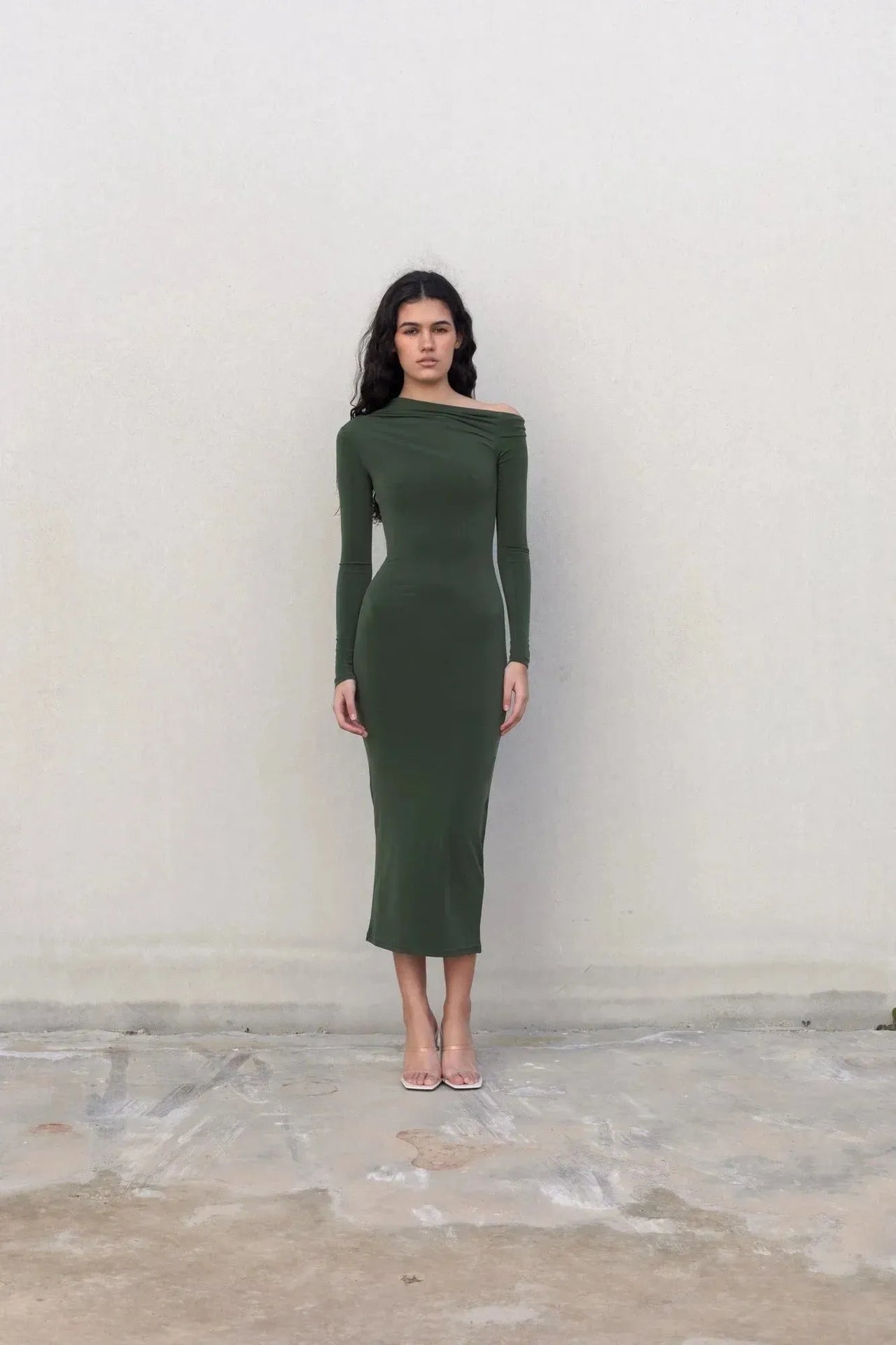 Modèle en robe moulante kaki femme à épaule dénudée, regardant l'objectif, illustrant l'élégance et le style contemporain de la robe moulante kaki.