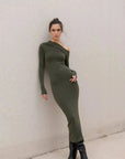 Modèle portant une robe moulante kaki femme à épaule dénudée contre un mur, mettant en valeur la coupe asymétrique de la robe moulante kaki.