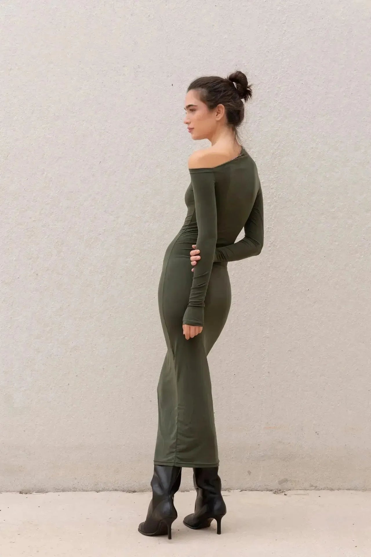 Profil d'un modèle en robe moulante kaki femme à épaule dénudée, illustrant la silhouette galbée offerte par la robe moulante kaki.