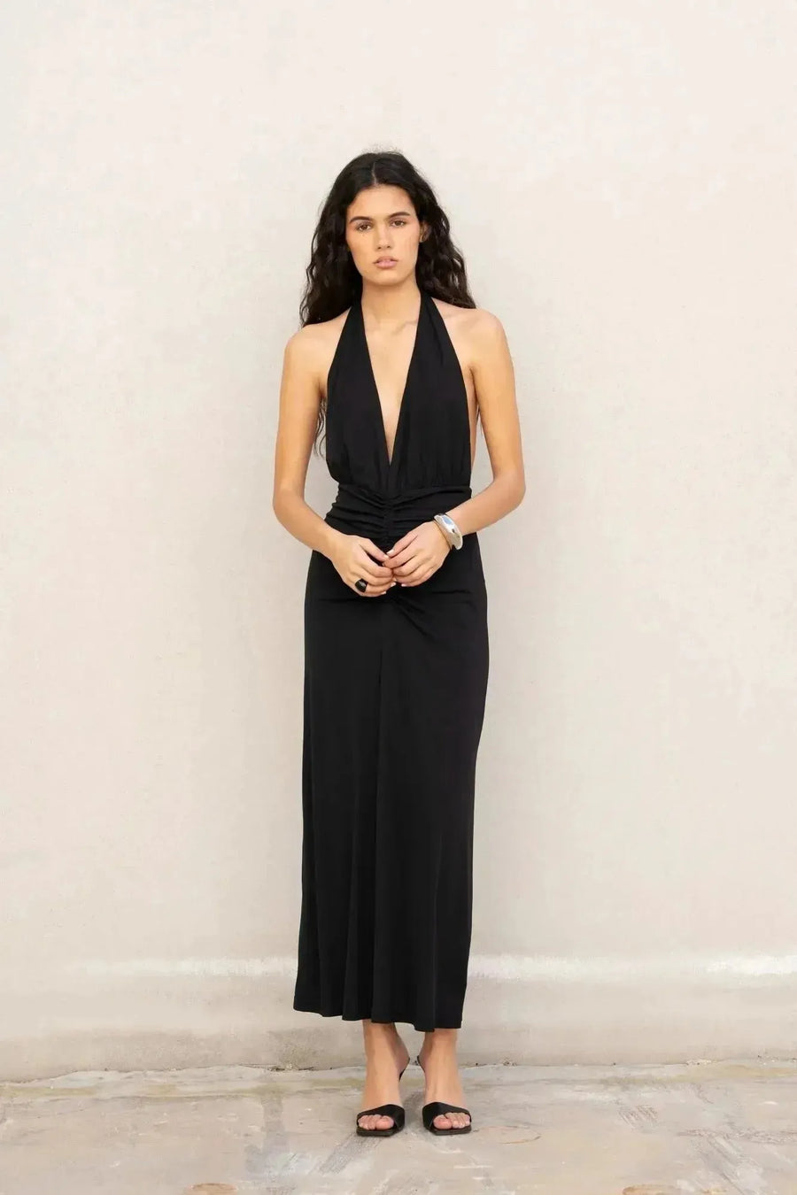 Modèle portant une robe longue noire dos nu, parfaite pour les événements chics. Idéale comme robe longue pour mariage invité chic.