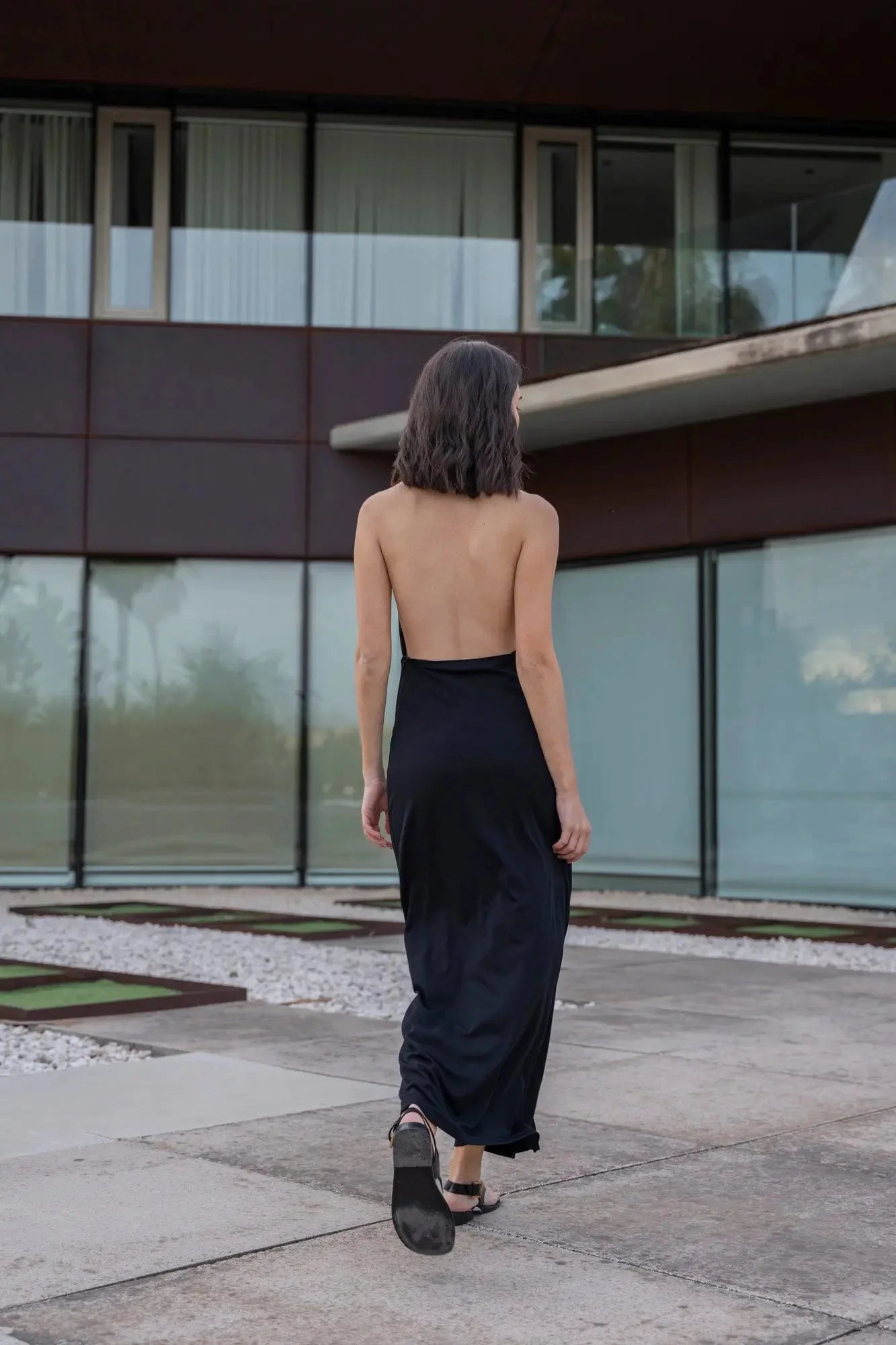 Femme en robe longue noire dos nu pour événements chics Élégance Sensuelle
