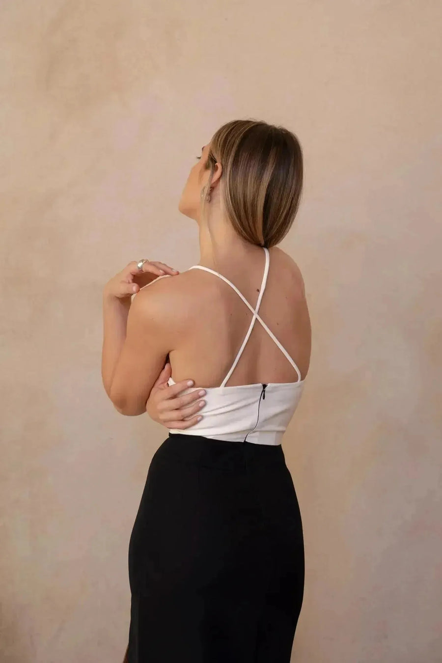 Vue arrière d'une robe marron femme midi bicolore à bretelles, montrant le style croisé des bretelles sur un fond neutre.