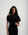 Détail de la robe asymétrique mi longue noire femme, élégance versatile pour soirées tendance 2024. Vue rapprochée du décolleté asymétrique, modèle chic et moderne.
