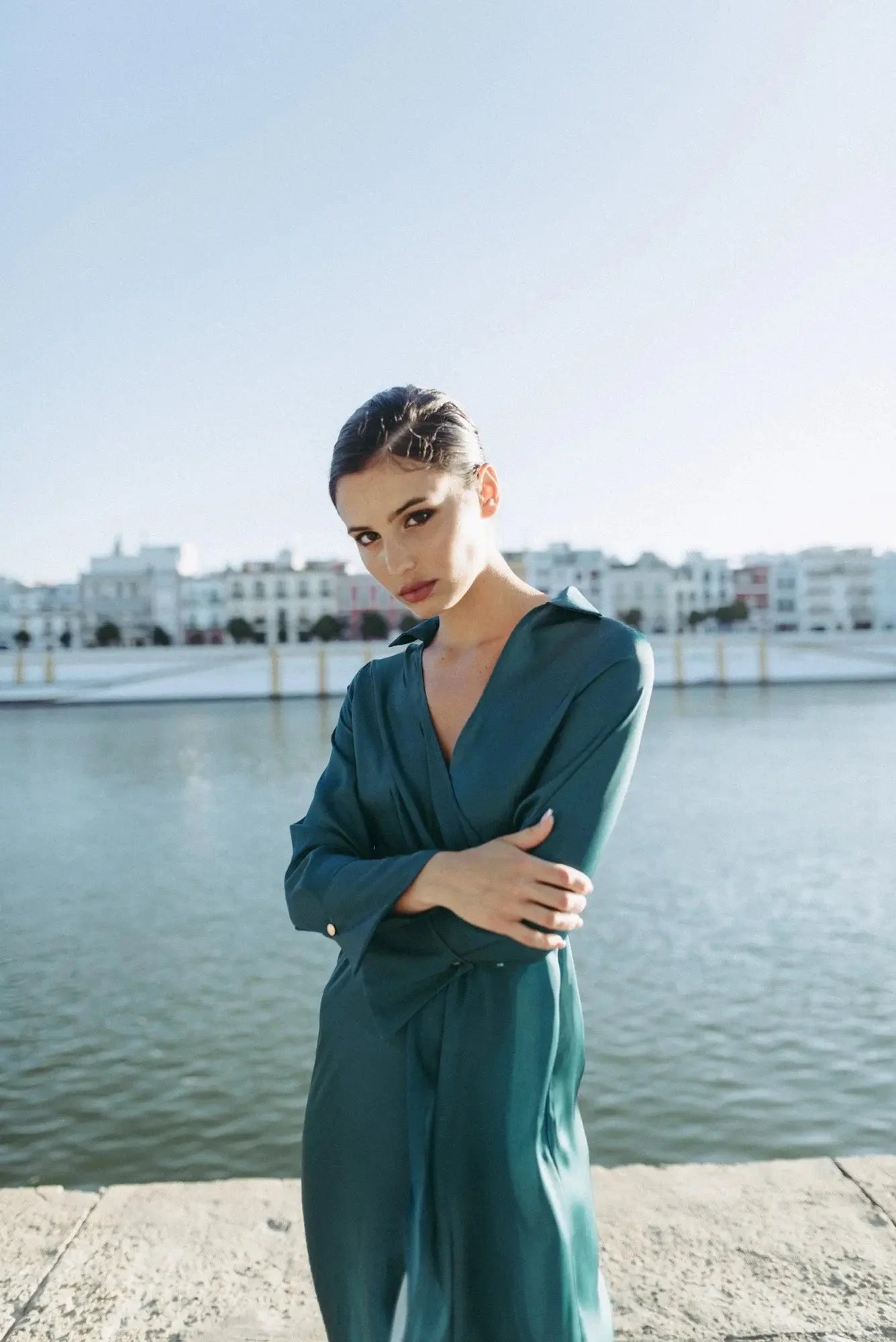 Femme portant une robe midi croisée en teal avec ceinture, élégance et confort