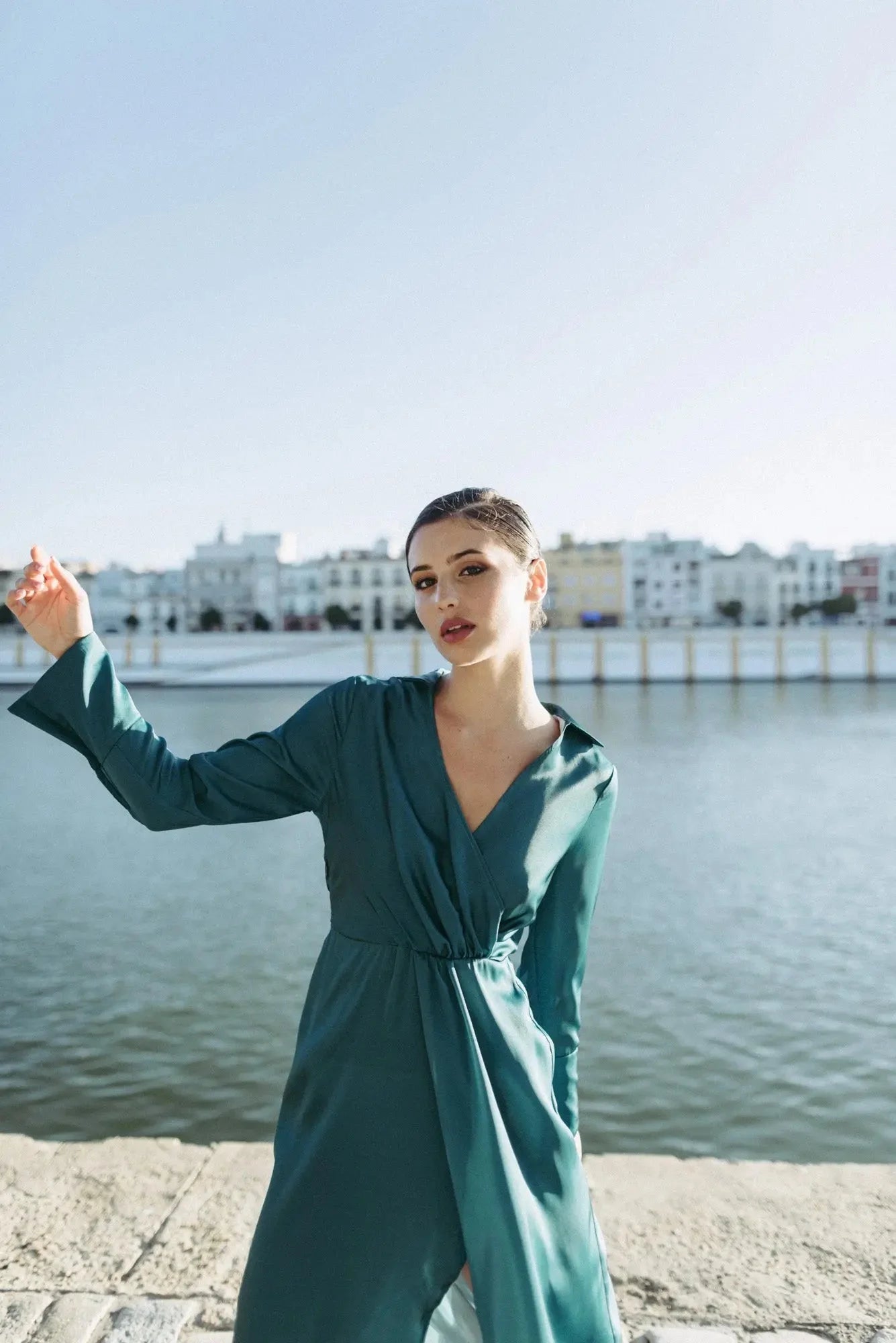 Femme en robe midi croisée fluide teal pour une élégance et confort parfaits