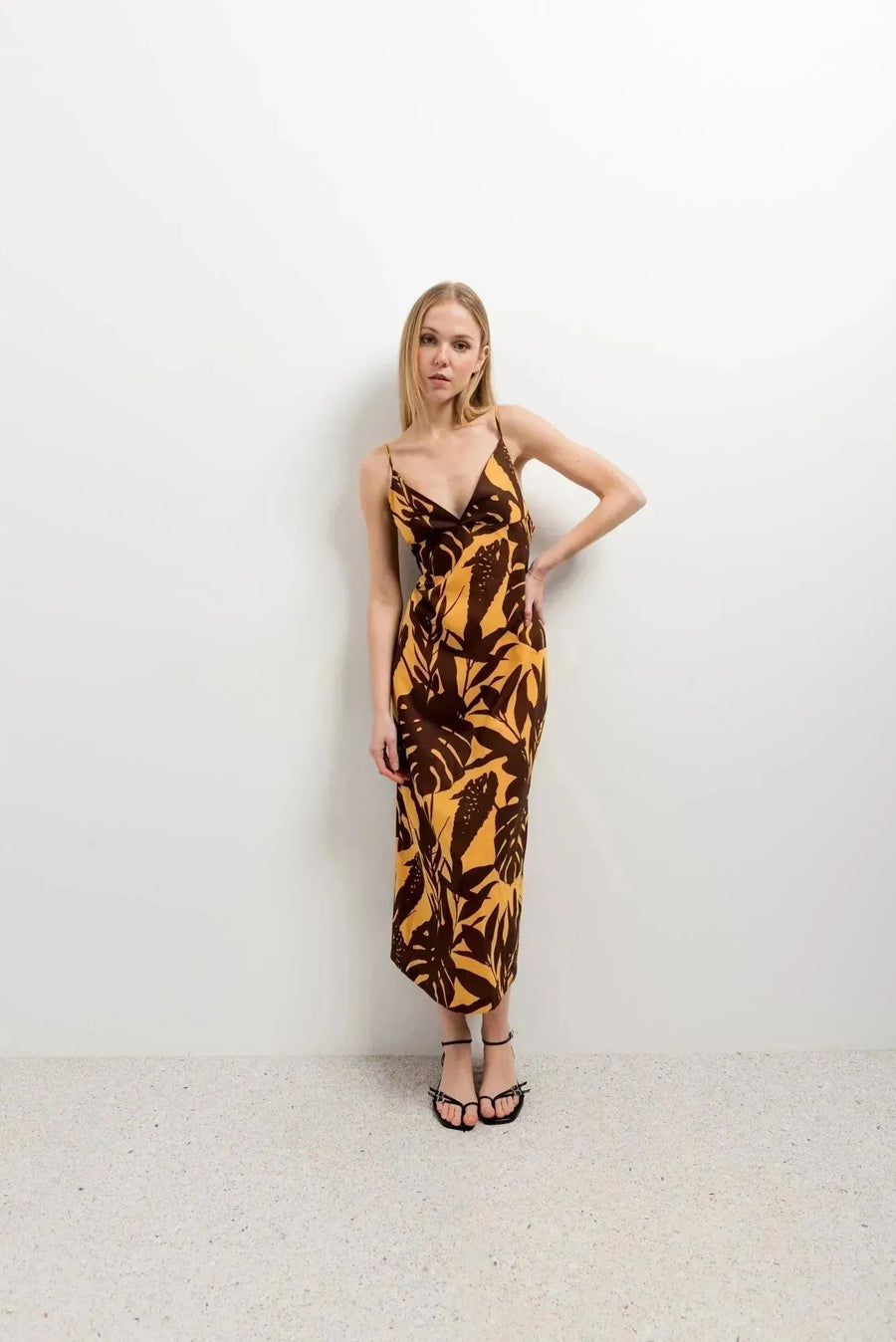 Modèle en robe imprimé tropical midi floral marron et jaune, affichant un style chic et décontracté.