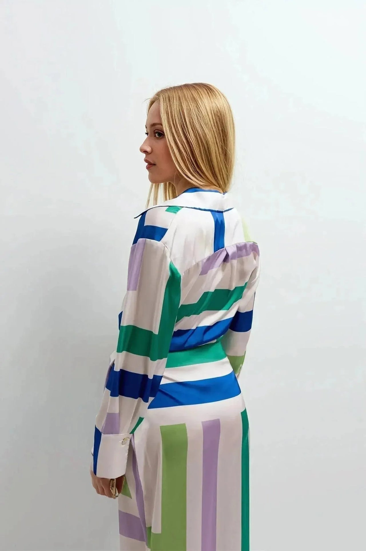 Femme montrant la robe midi imprimée portefeuille géométrique vue de dos. Idéale pour afficher une allure chic et décontractée.