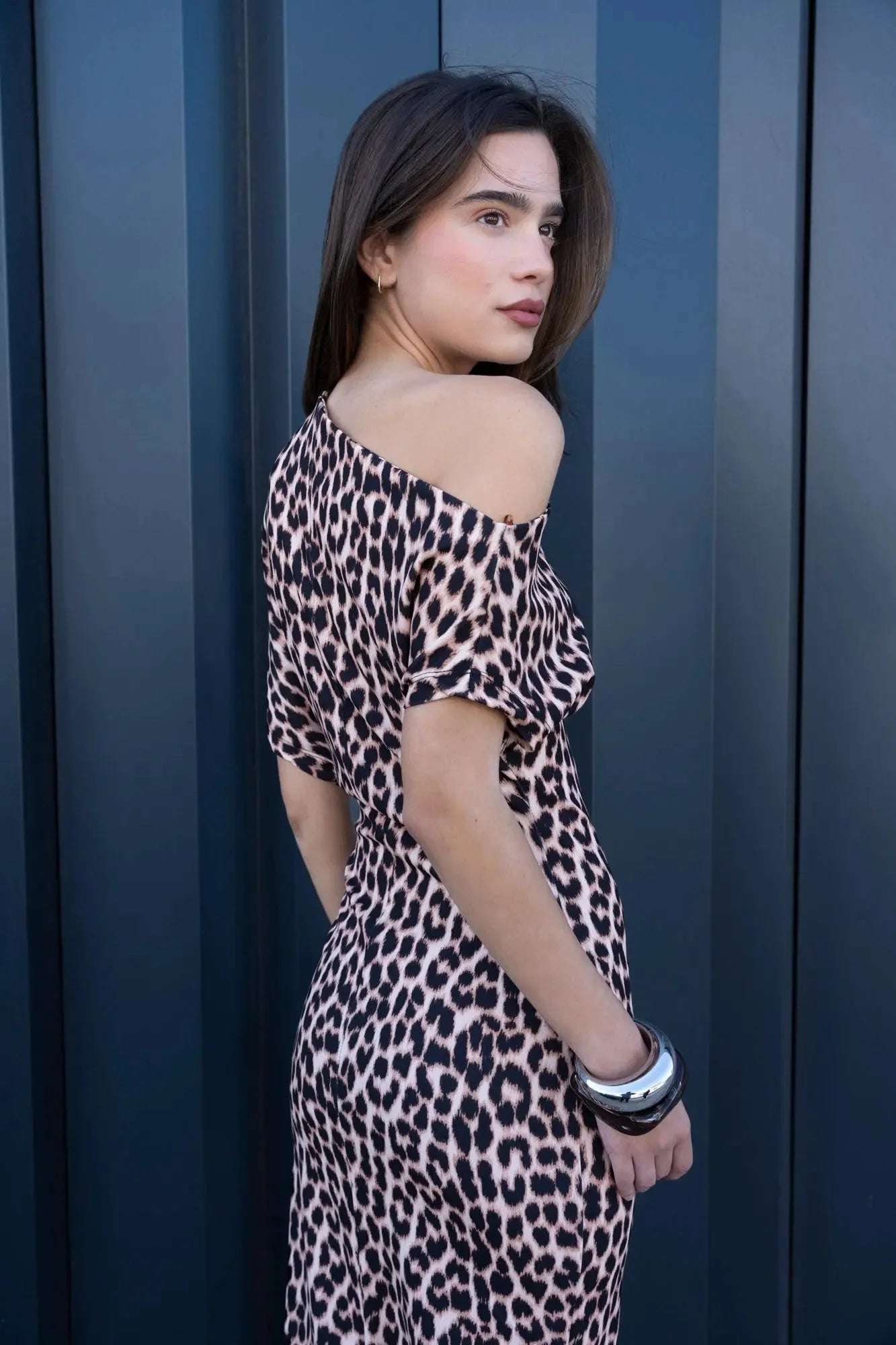 Femme portant une robe midi à imprimé animalier avec bracelets argent et noir