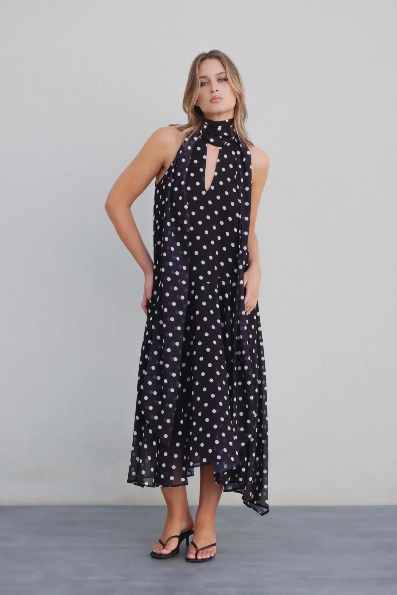 Robe noire à pois blancs midi avec col halter et découpe en clé sur le dos