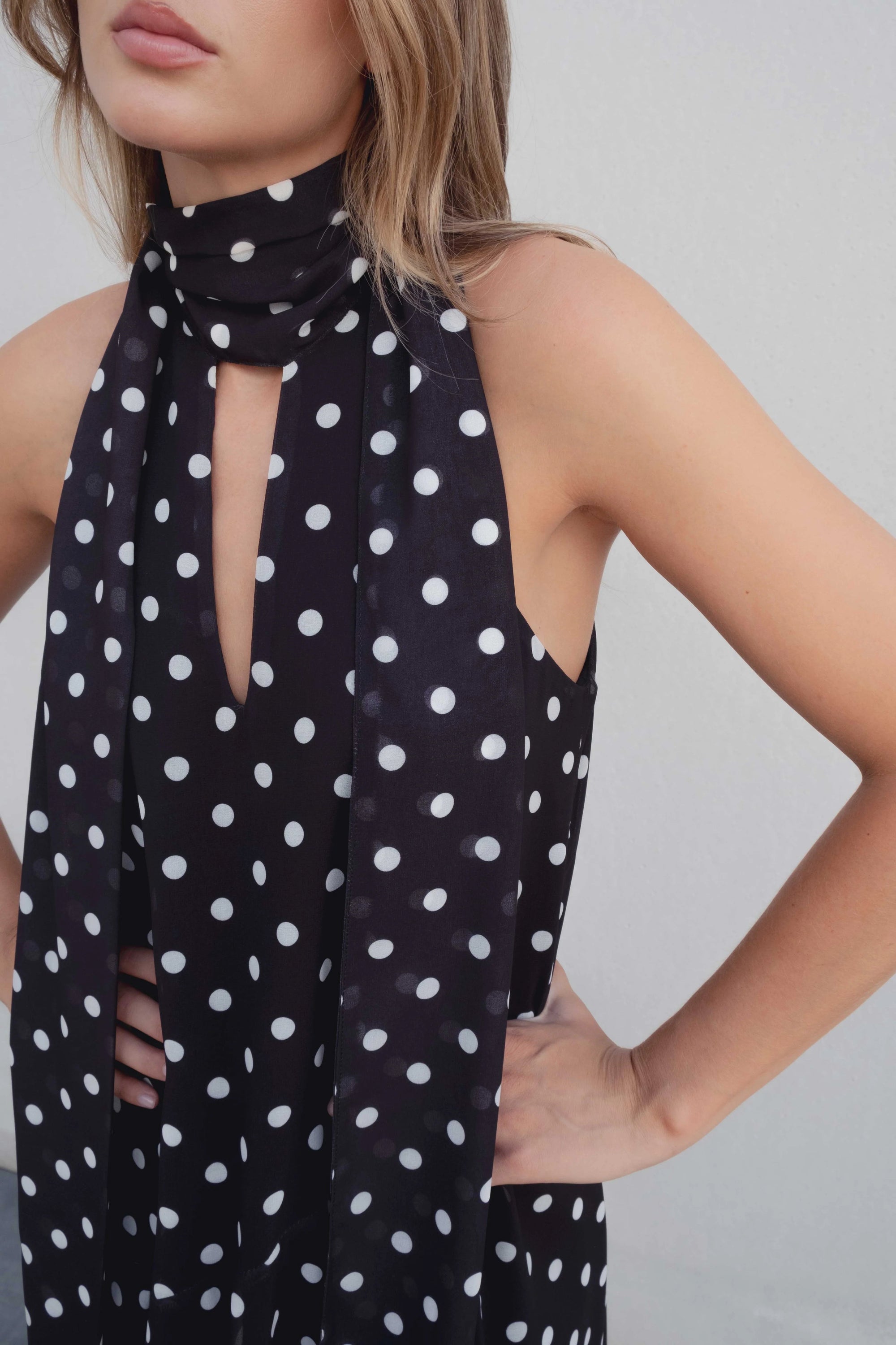 Robe noire à pois blancs fluide – col noué et coupe asymétrique Sapiato