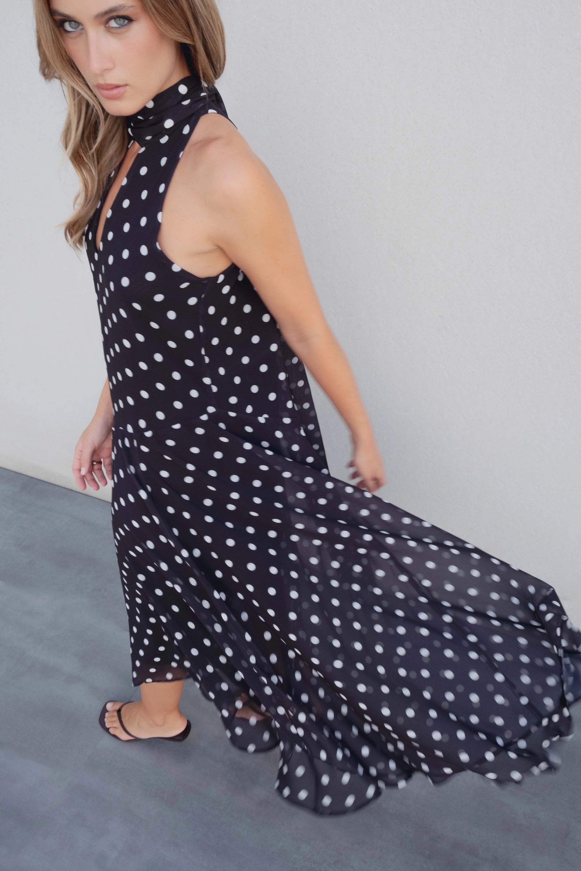 Robe noire à pois blancs fluide – col noué et coupe asymétrique Sapiato