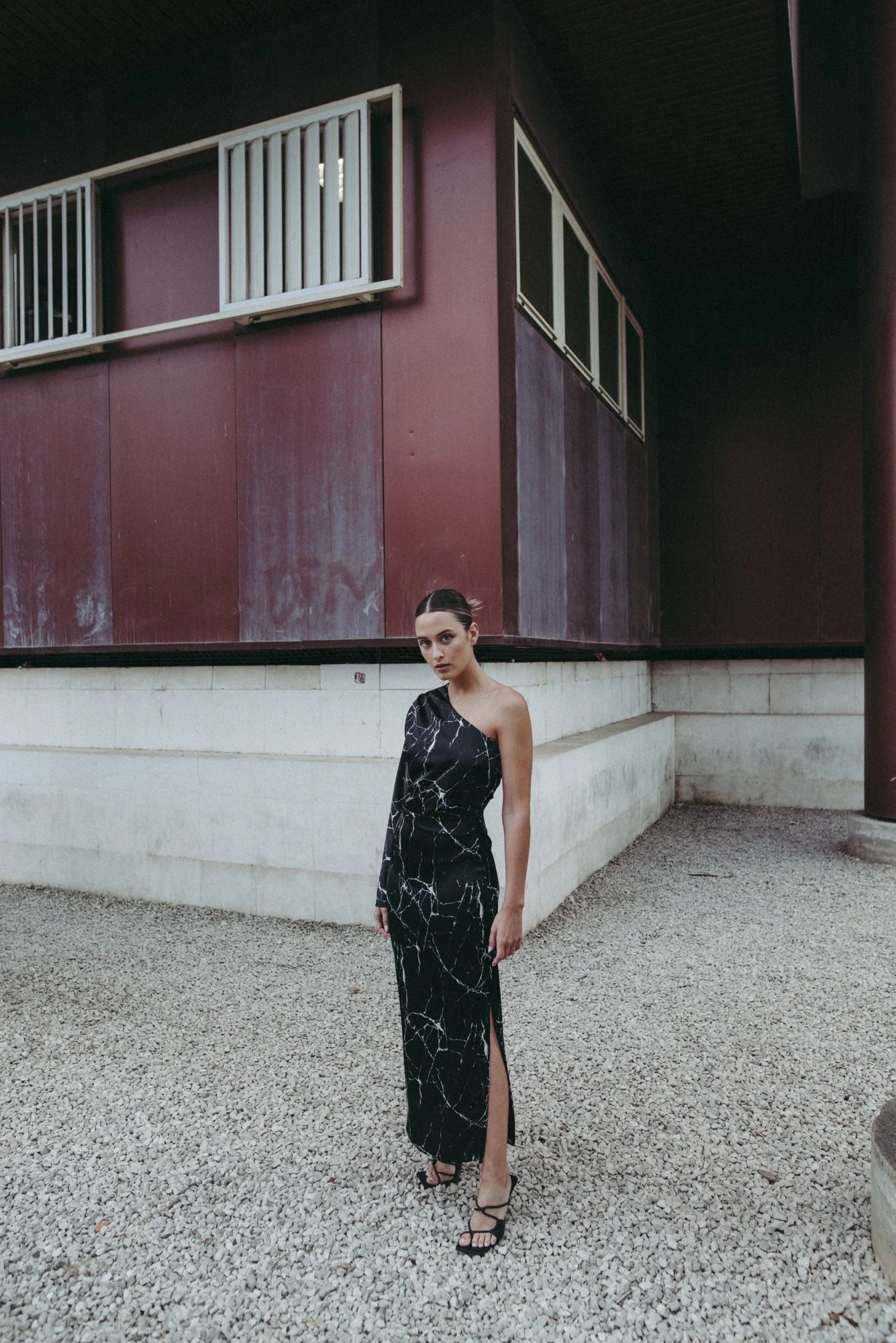 Vue rapprochée de la femme portant la Robe de Soirée Femme Asymétrique Satinée Noire Avec Imprimé Marbre, en mettant l’accent sur le design.