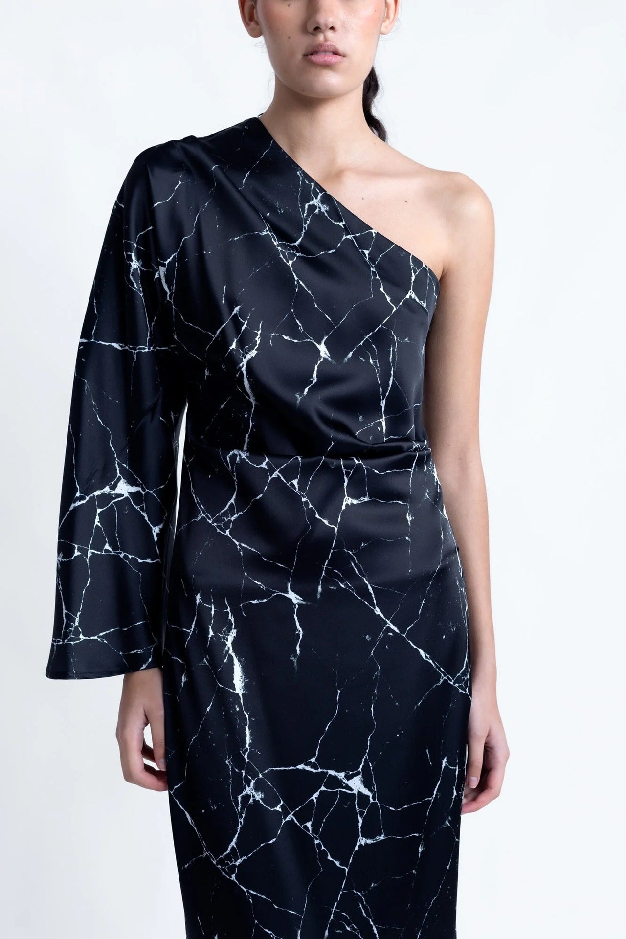 Détail de la Robe de Soirée Femme Asymétrique Satinée Noire Avec Imprimé Marbre, mettant en avant son motif élégant et moderne.