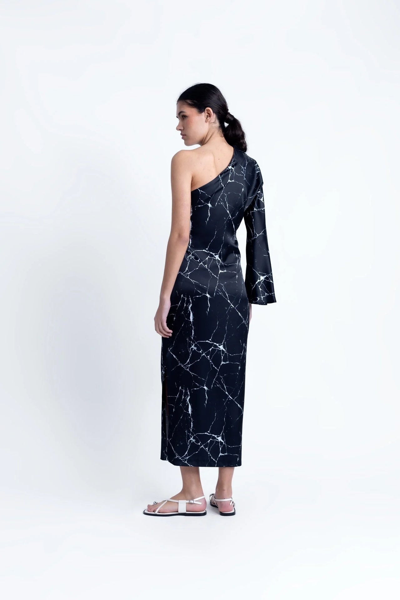 Vue arrière de la Robe de Soirée Femme Asymétrique Satinée Noire Avec Imprimé Marbre, montrant la coupe fluide et le design distinctif.