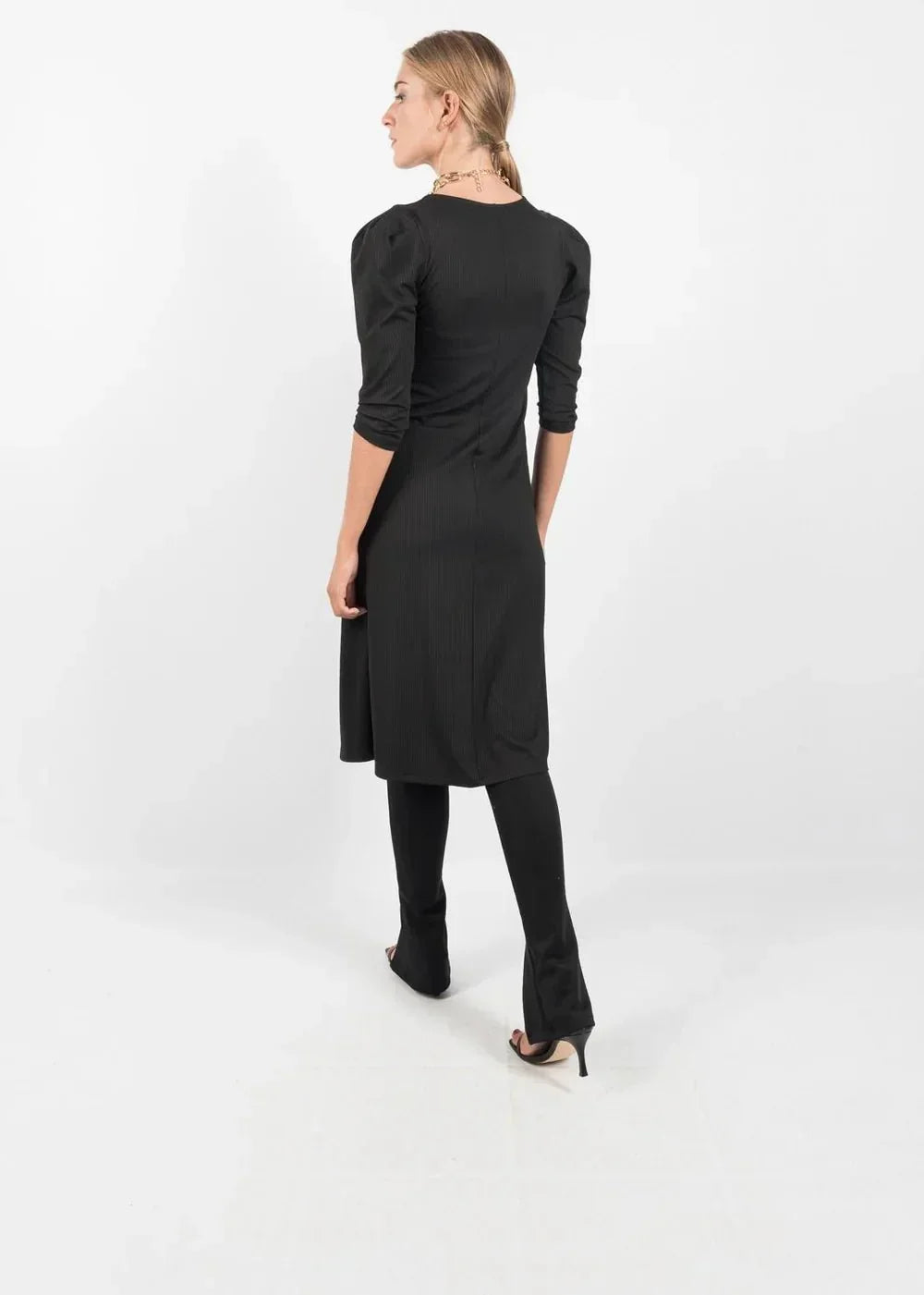 Robe noire mi-longue avec manches bouffantes et legging, style élégant et tendance