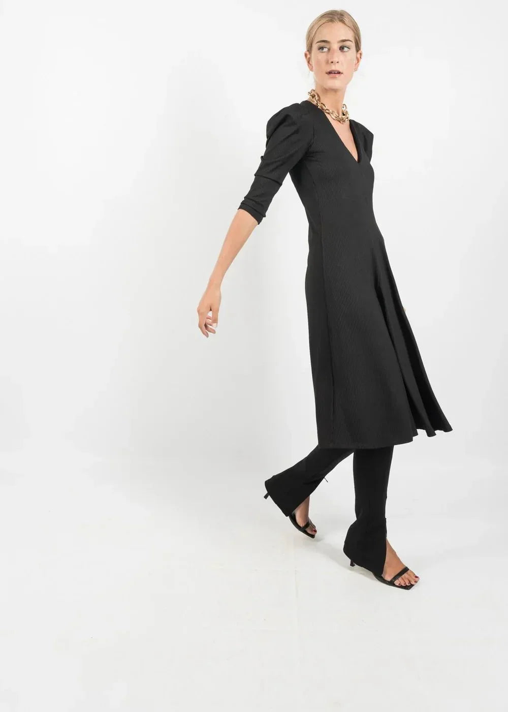 Robe noire mi-longue avec manches bouffantes et décolleté en V, élégante et tendance