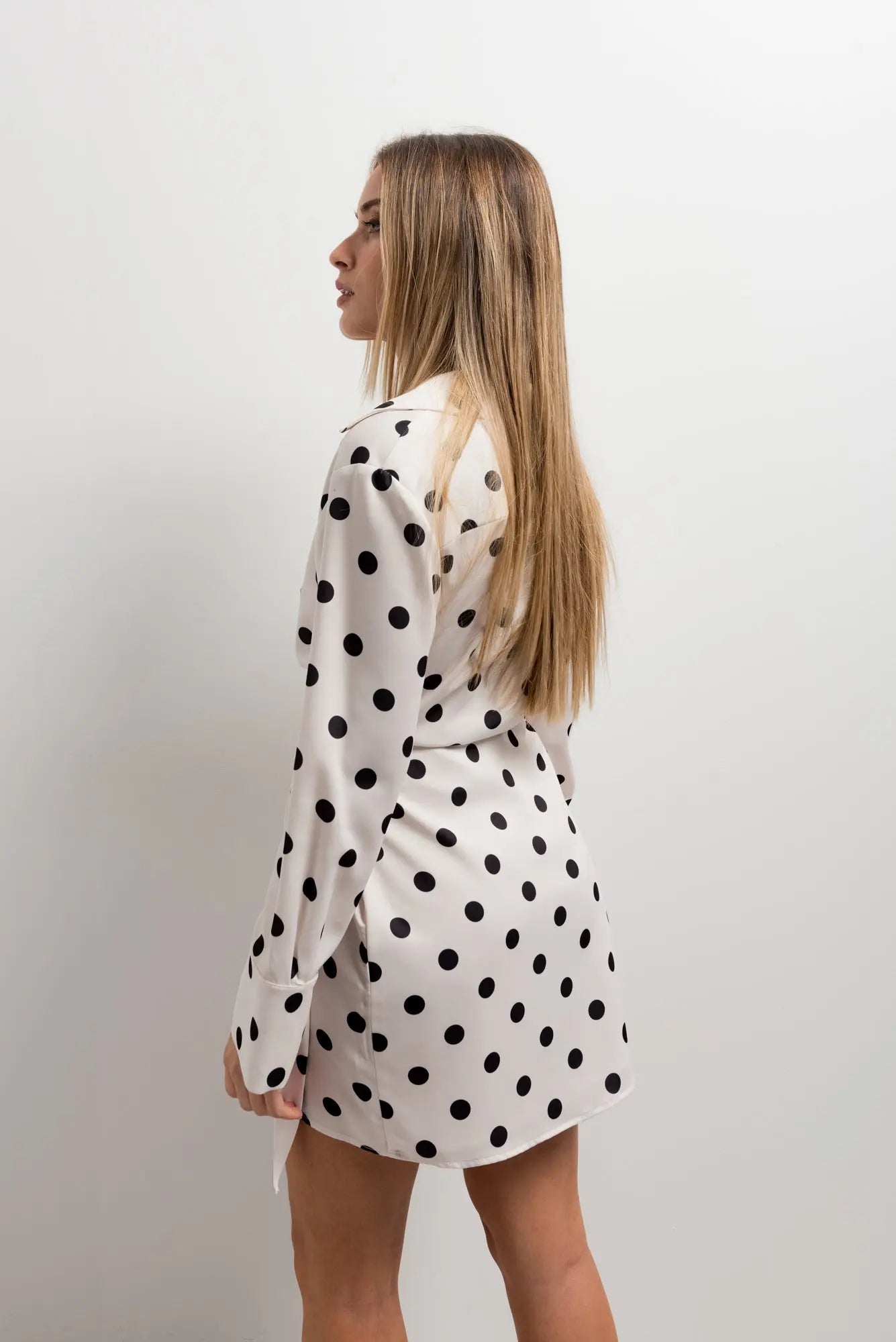 Robe portefeuille à pois noirs et blancs nouée à la taille portée par une femme