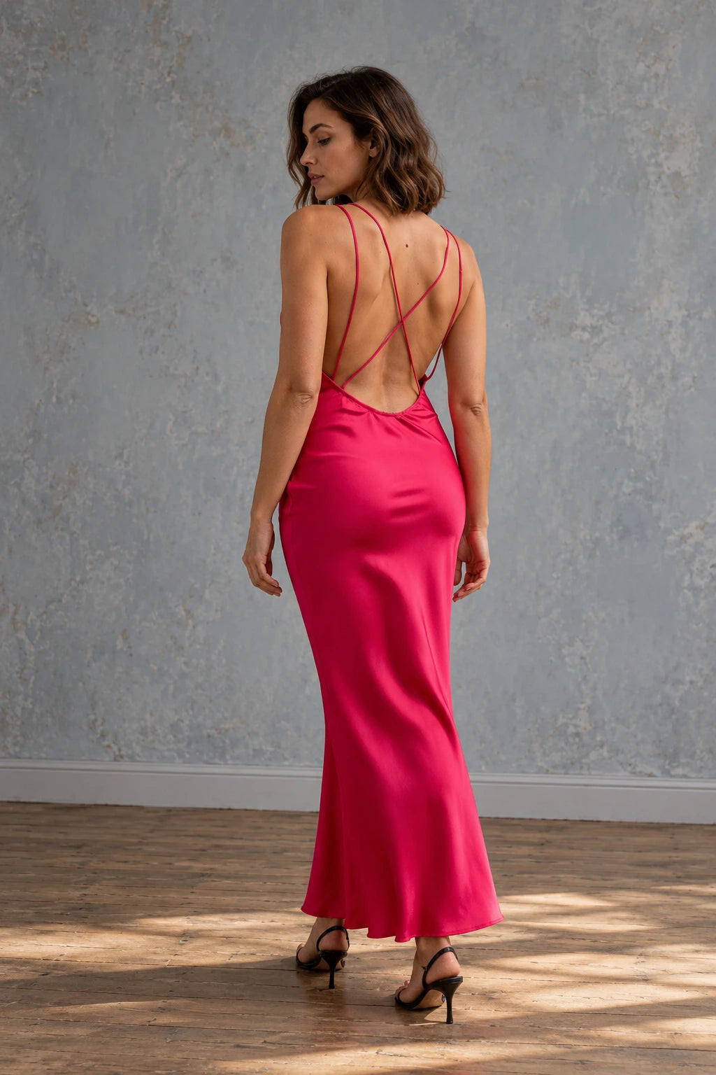 Vue arrière d'une robe dos nu satin rouge éclatant, mettant en valeur les bretelles délicates et le design fluide.