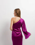 Vue arrière d'un modèle portant la robe midi asymétrique rose fuchsia en satin à une épaule, alliant sophistication et confort. Optez pour cette robe asymétrique de soirée.