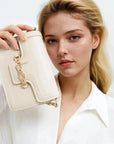 Femme tenant un sac à main crossbody beige en faux-leather avec chaîne or