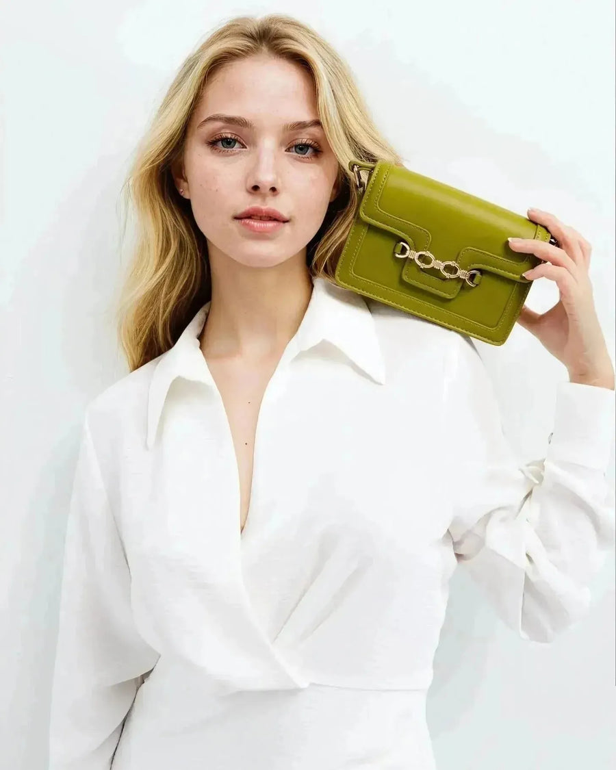 Femme blonde avec sac à main crossbody blanc à boucle, portant une robe blanche