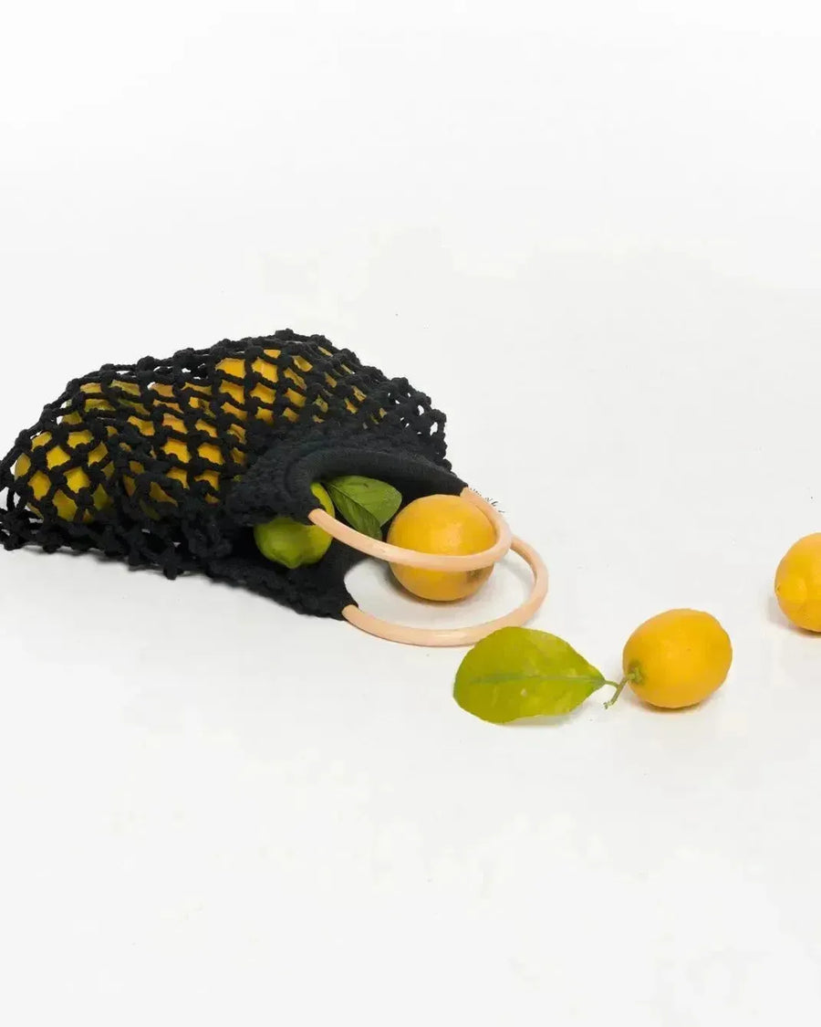 Sac à main noir en mesh rempli de citrons et de limes, élégant et pratique