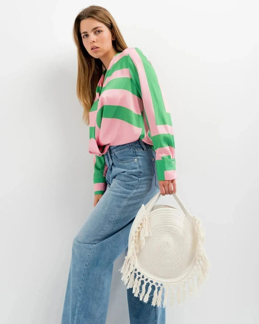 Femme avec sac panier rond en macramé à franges, veste à rayures rose et vert