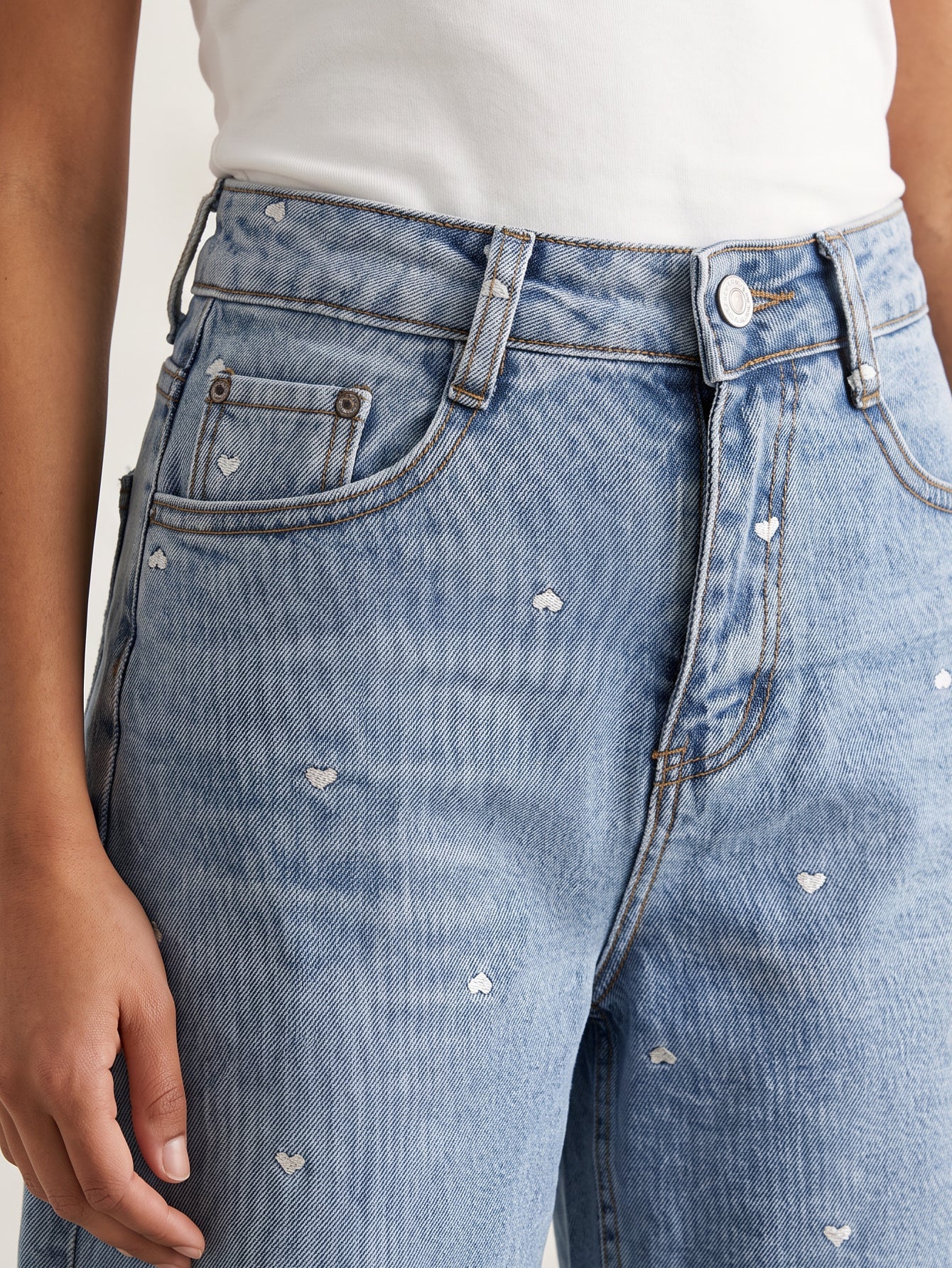 Détail taille passants et poches du bermuda en jean brodé