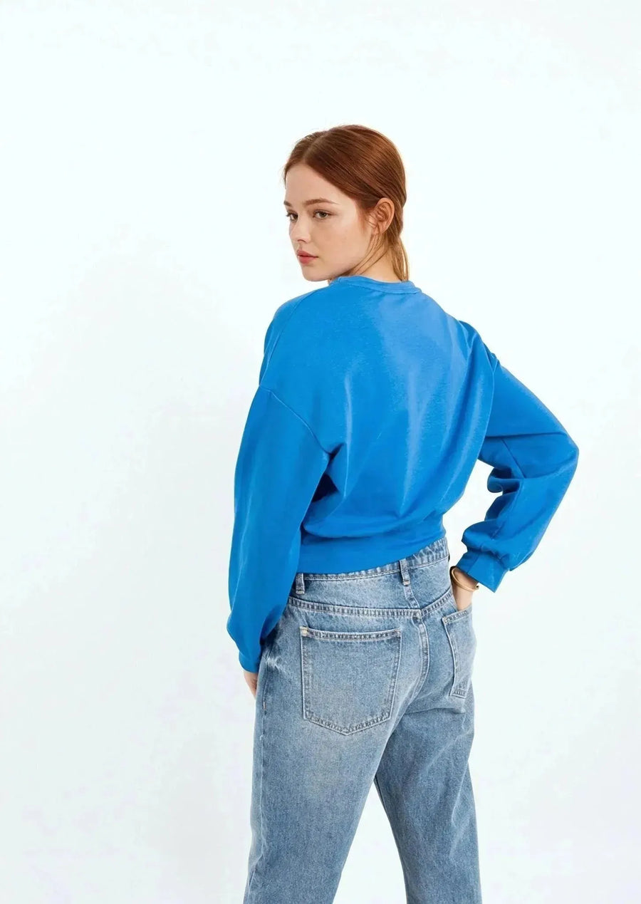 Femme portant un sweat-shirt court bleu ceinturé pour un look plus chic